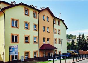ein großes gelbes Gebäude an der Straßenseite in der Unterkunft Hotel SANVIT RESTAURACJA & SPA in Sanok