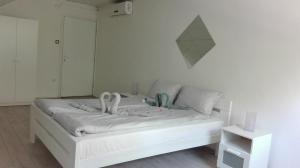 ein Schlafzimmer mit einem weißen Bett mit Schwänen darauf in der Unterkunft Apartment Dixy in Belgrad