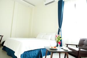 a bedroom with a bed and a table and a couch at Noblesse Hotel in Hai Phong