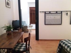 uma sala de estar com uma mesa e cadeiras e uma televisão em B&B il Cortile Malpensa em Casorate Sempione