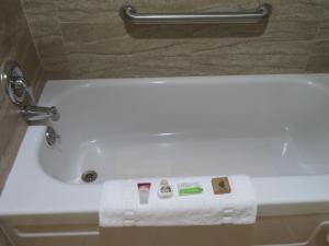 a white bath tub in a bathroom with a towel on it at Royal Crest Motel in Medford