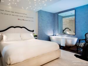 a bedroom with a bed and a tub and a mirror at Le Suite Di Giulietta in Verona