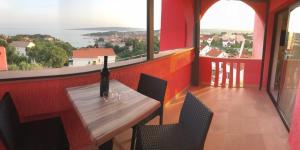 a dining room with a table with a bottle of wine at Apartmani Žužić in Krk
