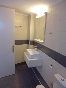 a bathroom with a sink and a toilet and a mirror at panorama studios in Afitos