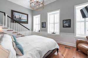 a bedroom with a bed and a staircase with windows at The Quarters on Vendue in Charleston