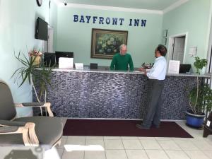 a man and a woman standing at a reception desk at Bayfront Inn Biloxi in Biloxi