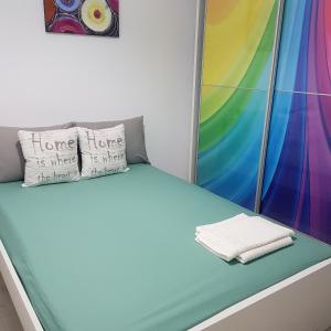 a bed in a room with a rainbow mural at Sarah Apartment in Constanţa