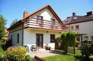 a house with a deck on the side of it at bliźniak-apartamenty in Rowy