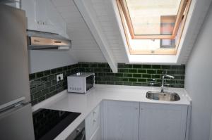 a small kitchen with a sink and a window at A Casa dos Nores Charming House in Cangas de Morrazo