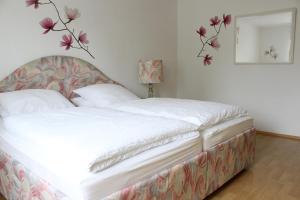 a bedroom with a white bed with flowers on the wall at Ferienwohnung Antes in Heppenheim an der Bergstrasse