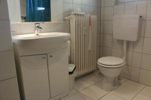 a white bathroom with a toilet and a sink at Ferienwohnung Antes in Heppenheim an der Bergstrasse