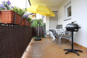 a grill and an umbrella on a patio at Ferienwohnung Antes in Heppenheim an der Bergstrasse