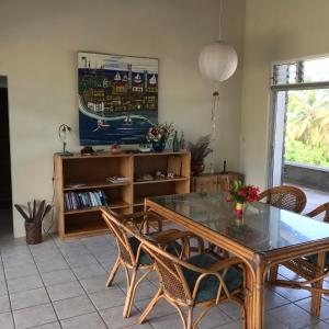 a dining room with a glass table and chairs at Garden Bungalow in Sauteurs