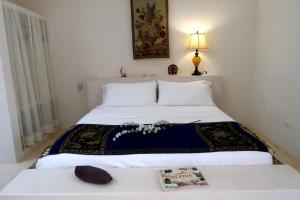a bedroom with a bed with a book on it at Hotel Casa de Campo Conkal Merida in Conkal