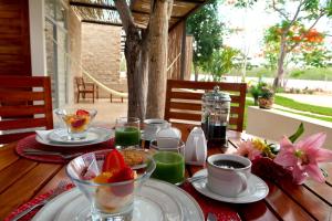 einen Holztisch mit Speisen und Getränken darauf in der Unterkunft Hotel Casa de Campo Conkal Merida in Conkal