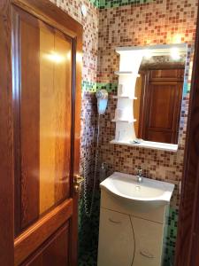 a bathroom with a sink and a mirror at Regina Hotel in Vasilátika