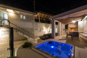 a hot tub on the patio of a house at night at Villa Hurem in Trogir