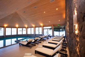 una piscina con tumbonas y una piscina en Valle Corralco Hotel & Spa, en Malalcahuello