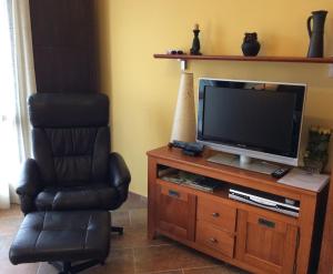 a living room with a chair and a television at Balcón De Garbisón in Roda de Isábena
