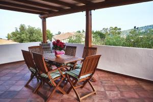 drewniany stół i 4 krzesła na patio w obiekcie Villetta Stella IUN P2177 w mieście Cala Gonone