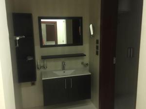 a bathroom with a sink and a mirror at Nourth House ApartHotel in Al Qurayyat