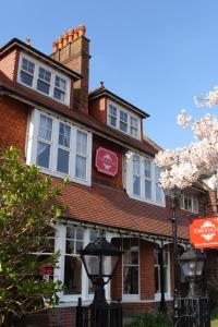 a red brick house with white windows and a street light at Tower House 1066 in Hastings