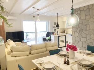 a living room with a couch and a table at Colours Seaview Apartment in Nea Artaki