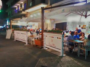 a group of people sitting at tables under umbrellas at Versomare in Polignano a Mare