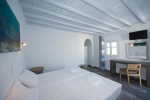 una stanza bianca con un letto e una scrivania di MARKOS BEACH rooms & studios a Mykonos Città Altre 113 foto