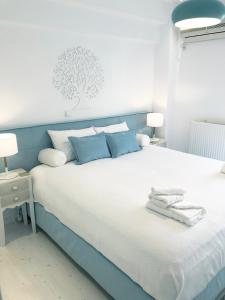 a blue and white bed with towels on it at Colours Seaview Apartment in Nea Artaki