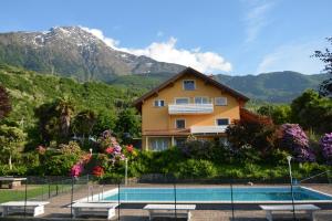 a house with a swimming pool in front of a mountain at Casa Bellavista 1 in Colico