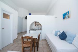 un soggiorno con un divano bianco e un tavolo di MARKOS BEACH rooms & studios a Mykonos Città