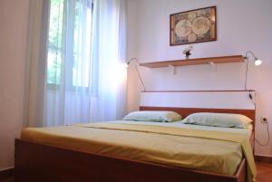 1 dormitorio con 1 cama con cabecero y ventana en Old Town Uspon, en Pula