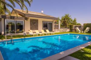 a swimming pool in front of a house at Villa Oras in Mascali