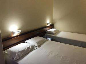 a hotel room with two beds and two lamps at Oft Plaza Oeste Hotel in Goiânia