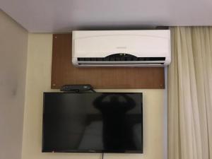 a television with a air conditioner on top of it at Oft Plaza Oeste Hotel in Goiânia