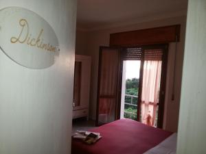 a bedroom with a bed and a large window at Hotel Signorini in Castiglioncello