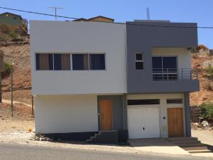 a large white house with two garage doors at T1 Família Luz in Mindelo