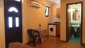uma cozinha com uma mesa, um lavatório e uma porta em Villa Budvanka Guesthouse em Budva