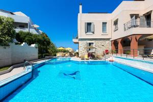 a swimming pool in the middle of a building at Philoxenia Apartments in Panormos Rethymno