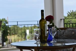 a bottle of wine sitting on a table with two glasses at Garden Villas in Koroni