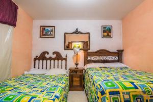 a bedroom with two beds and a mirror at Casa De Leon in Antigua Guatemala