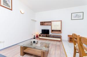 a living room with a table and a tv at Apartments and Rooms Iva in Trogir