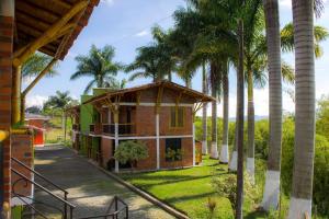 una casa con palmeras delante en Palmas De Santa Elena, en Quimbaya