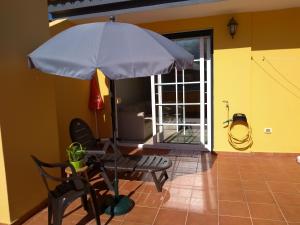 a table and a chair with an umbrella in a room at PLAYA Y MONTAÑA: NATURALEZA Y ARMONÍA in La Laguna +45 photos