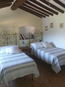 a bedroom with two beds and a wooden floor at Le Travi in Sarzana