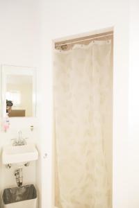 a bathroom with a shower curtain and a sink at Orange Drive Hostel in Los Angeles