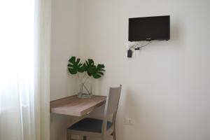 a room with a desk and a tv and a plant at Le Tre Orchidee Florence in Florence