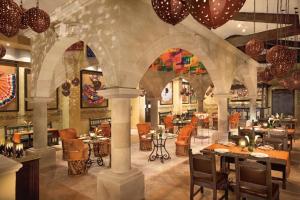 a restaurant with tables and chairs in a building at Dreams Riviera Cancun Resort & Spa - All Inclusive in Puerto Morelos