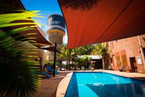 a swimming pool with a water tower in the background at Mercure Hotel Mildura in Mildura